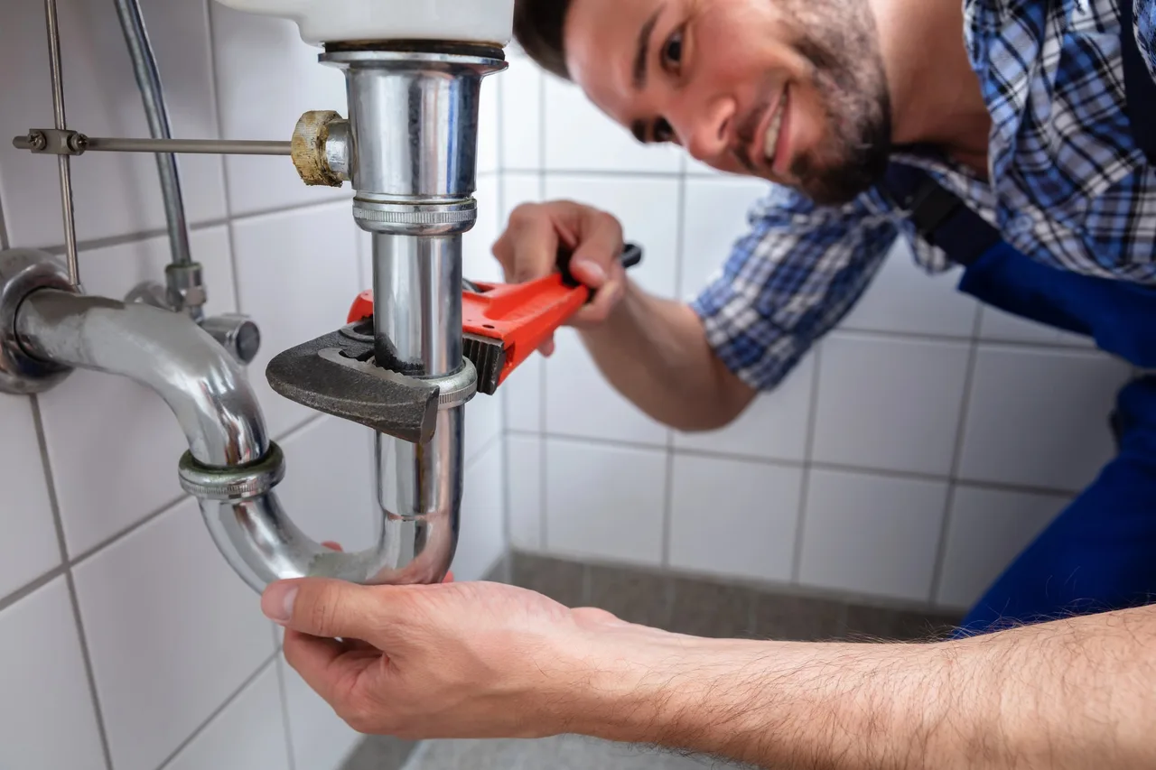 Plombier au travail sur un raccordement dans le Gâtinais